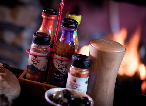 Nando's sauces and salts with a carrier and olives